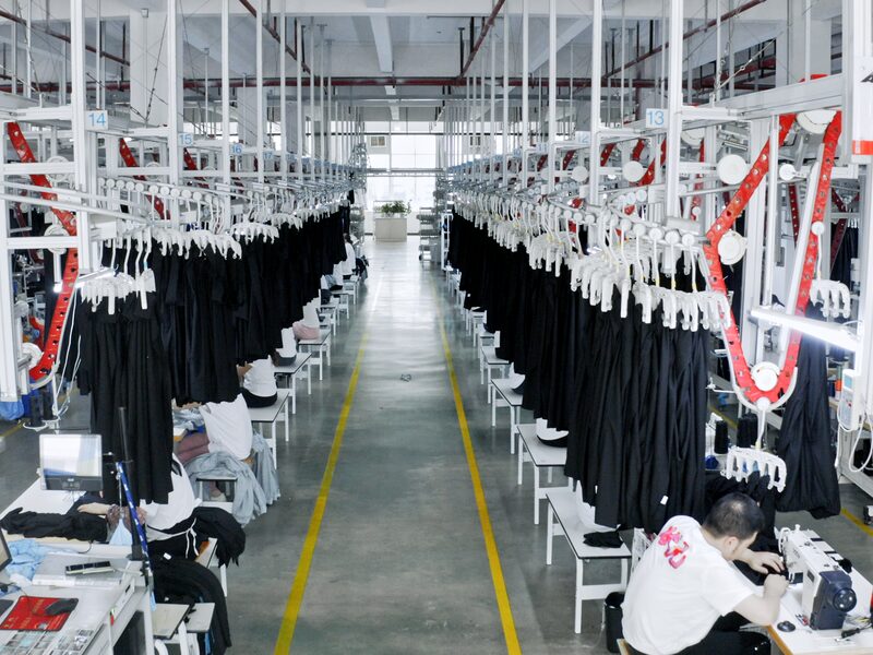 Overhead hanging conveyor carrying shoe uppers along the stitching line