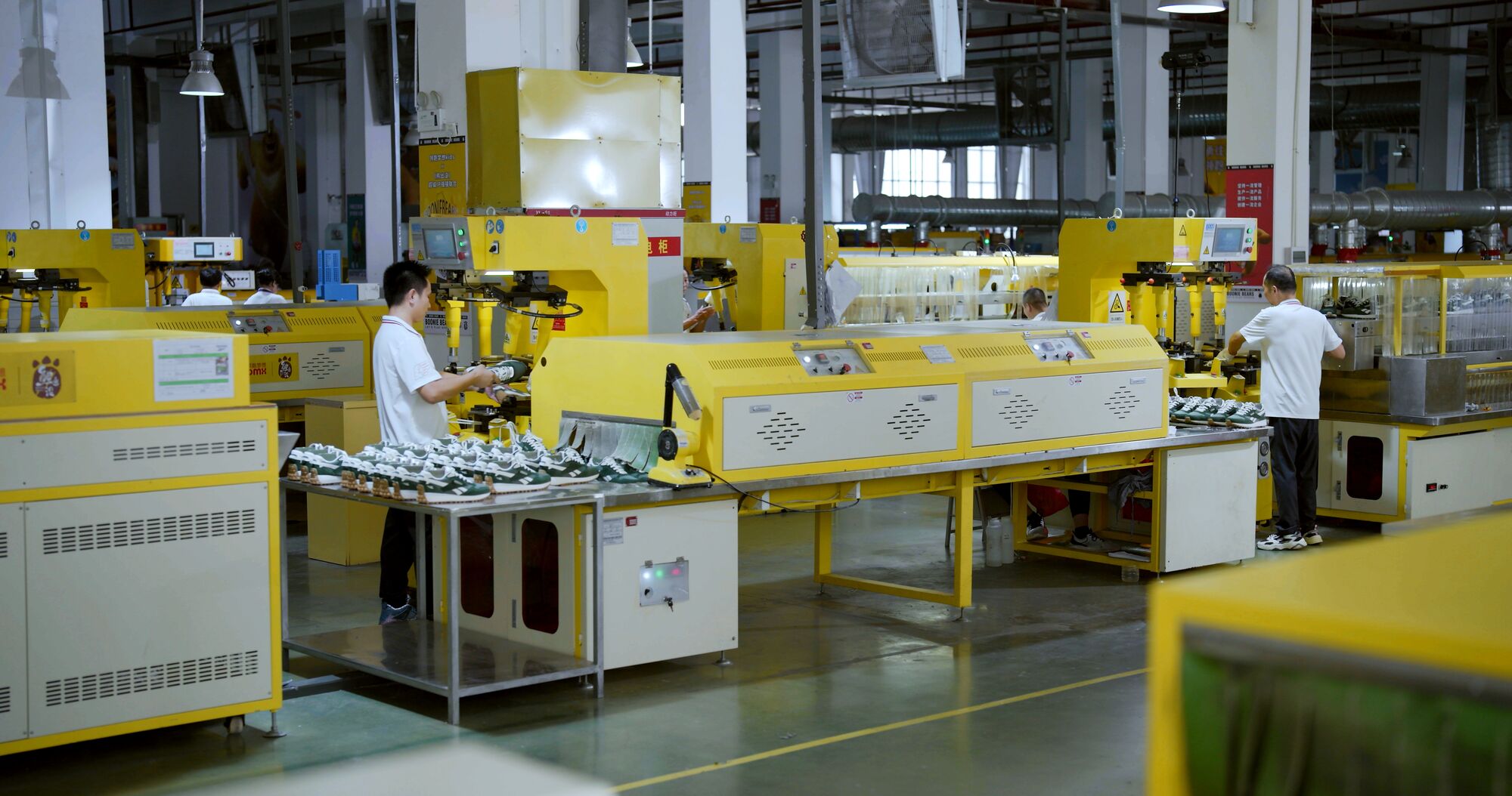 Shoe assembly line in production — lasting machines building sneakers in a factory